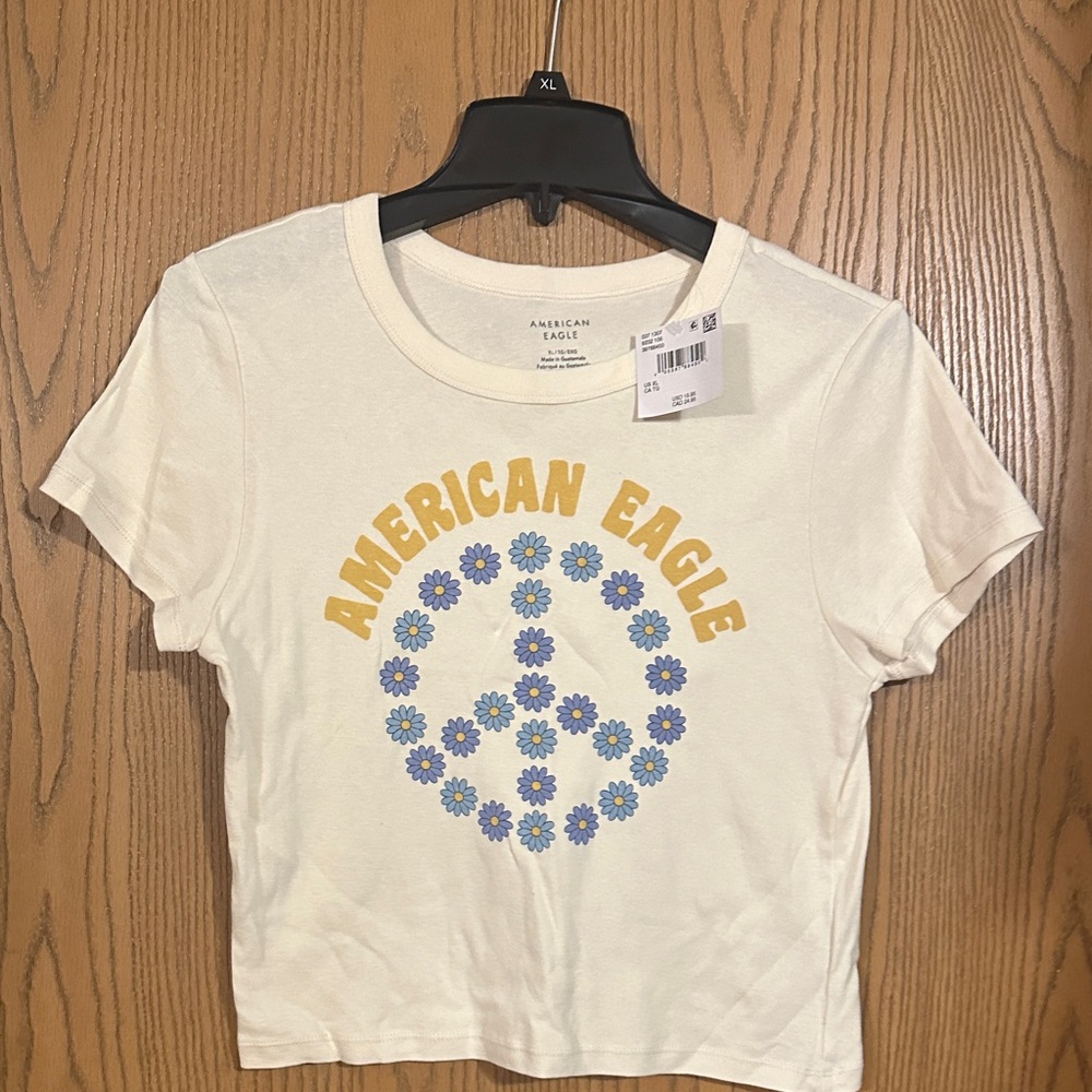 American Eagle Outfitters Cream Tee with Blue Daisy Peace Sign